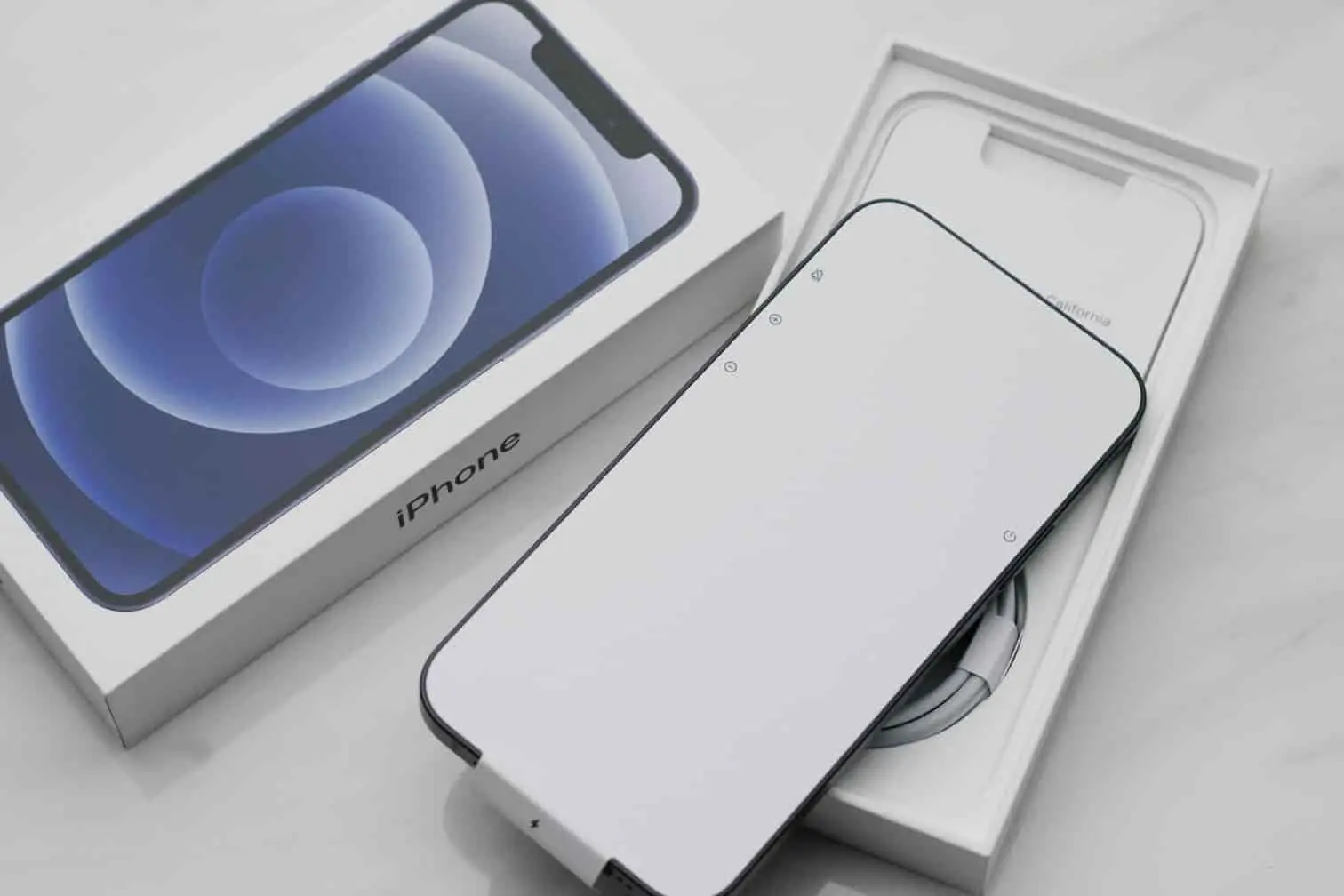 iPhone en cours de déballage, illustrant les différences de design et de fonctionnalités entre les modèles 16 et 16e.