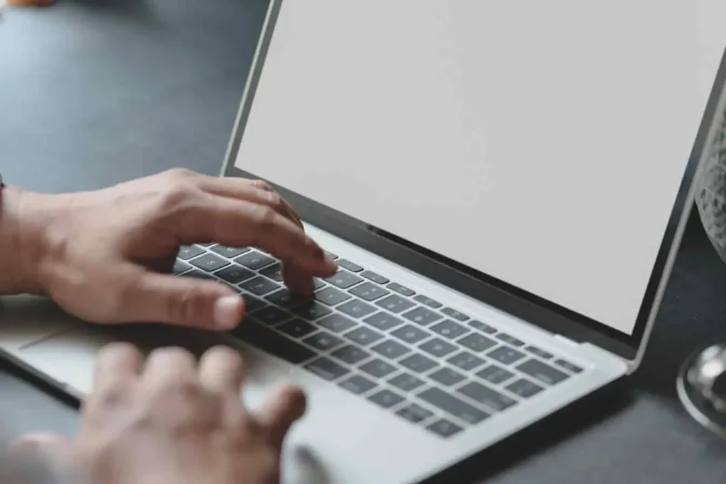 Utilisateur tapant sur un clavier pour tenter de récupérer la corbeille supprimée sur Windows, écran vide en attente de solution.