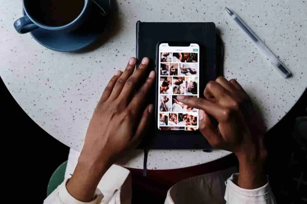 Smartphone affichant des images Instagram, doigt prêt à cliquer, ambiance détendue, image liée à la sauvegarde de vidéos