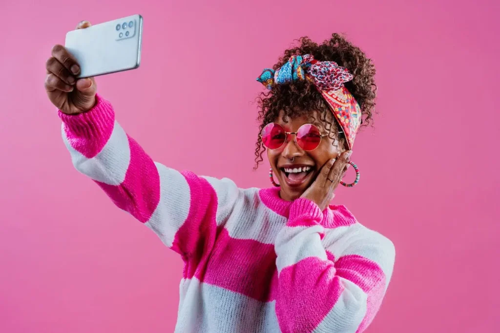 Influenceuse souriante en selfie coloré, image illustrant la mise en avant d’un média kit professionnel pour décrocher des partenariats