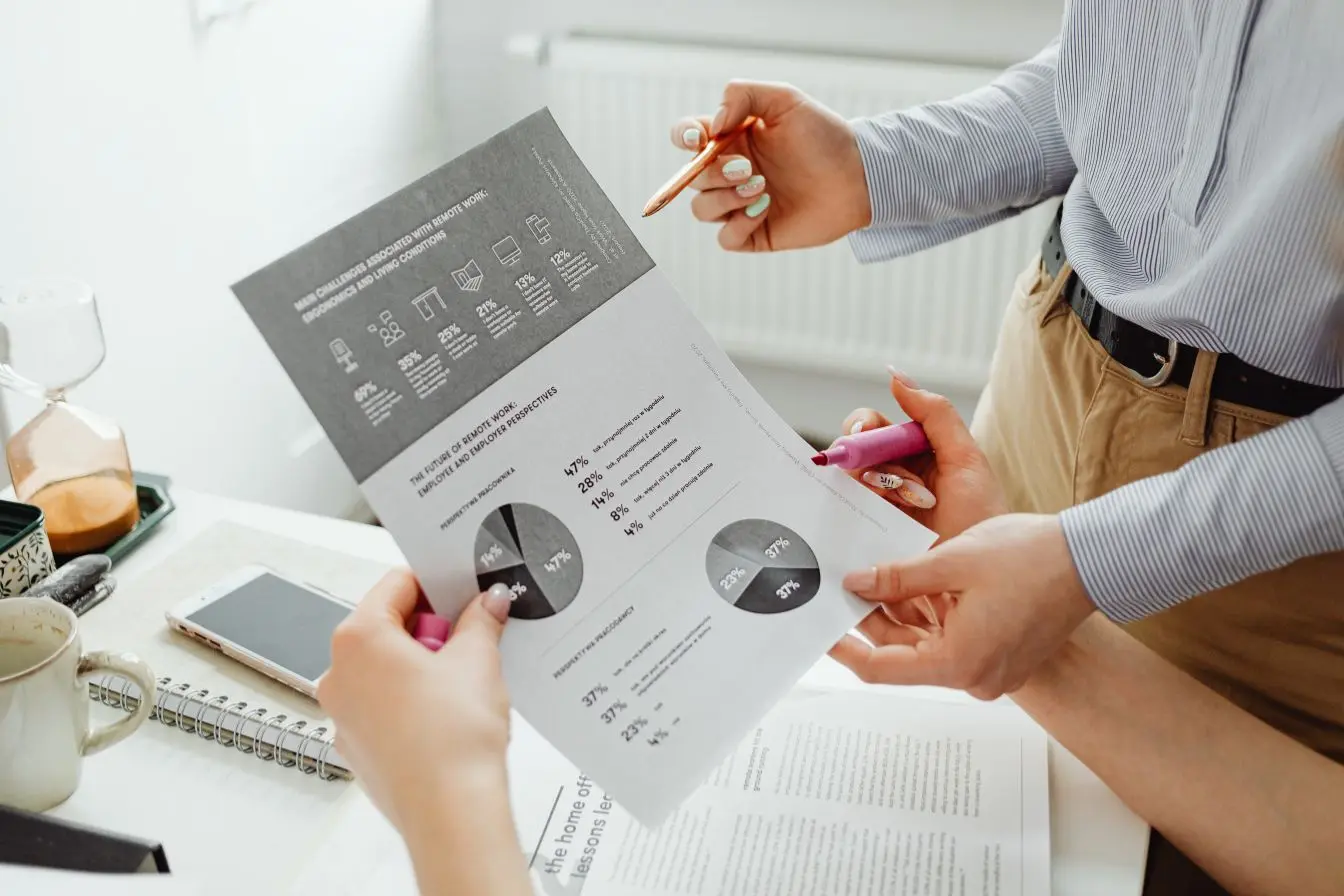 Deux personnes analysant un document avec graphiques, image illustrant le NPS qui mesure la satisfaction et la fidélité des employés