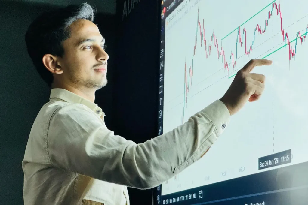 Écran géant avec courbes Bitcoin et main désignant un point clé représentant la stratégie de buzz marketing autour des données financières.