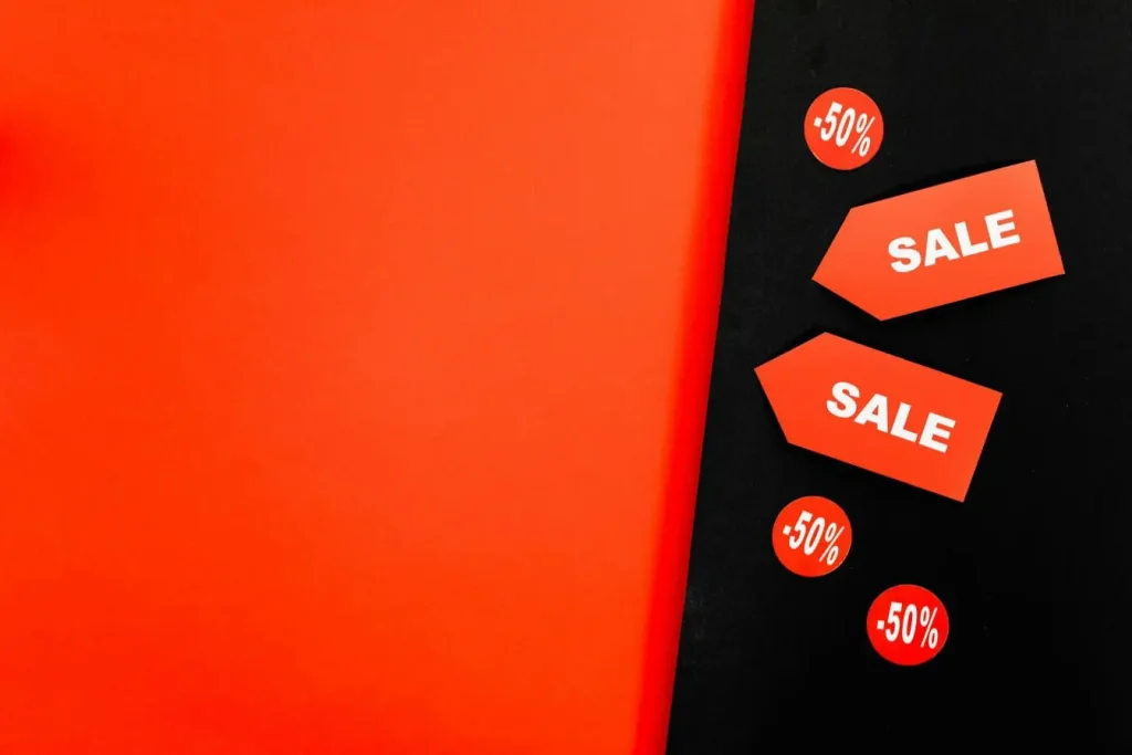Tags rouges SALE et -50% sur fond contrasté, montrant comment les promotions traduisent un churn rate élevé et une clientèle volatile.