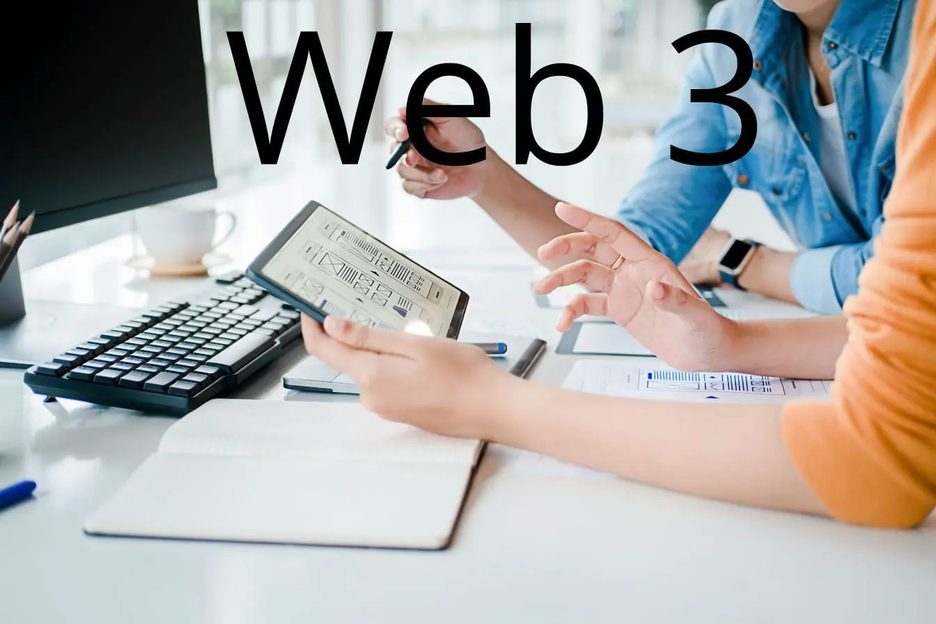 Deux personnes discutant autour d’un schéma numérique sur tablette, image illustrant la collaboration et l’innovation liées au Web3.