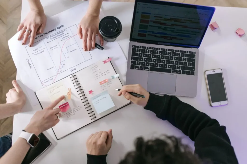 Table de travail avec graphique financement startup et ordinateur, image illustrant le bootstrapping en startup.