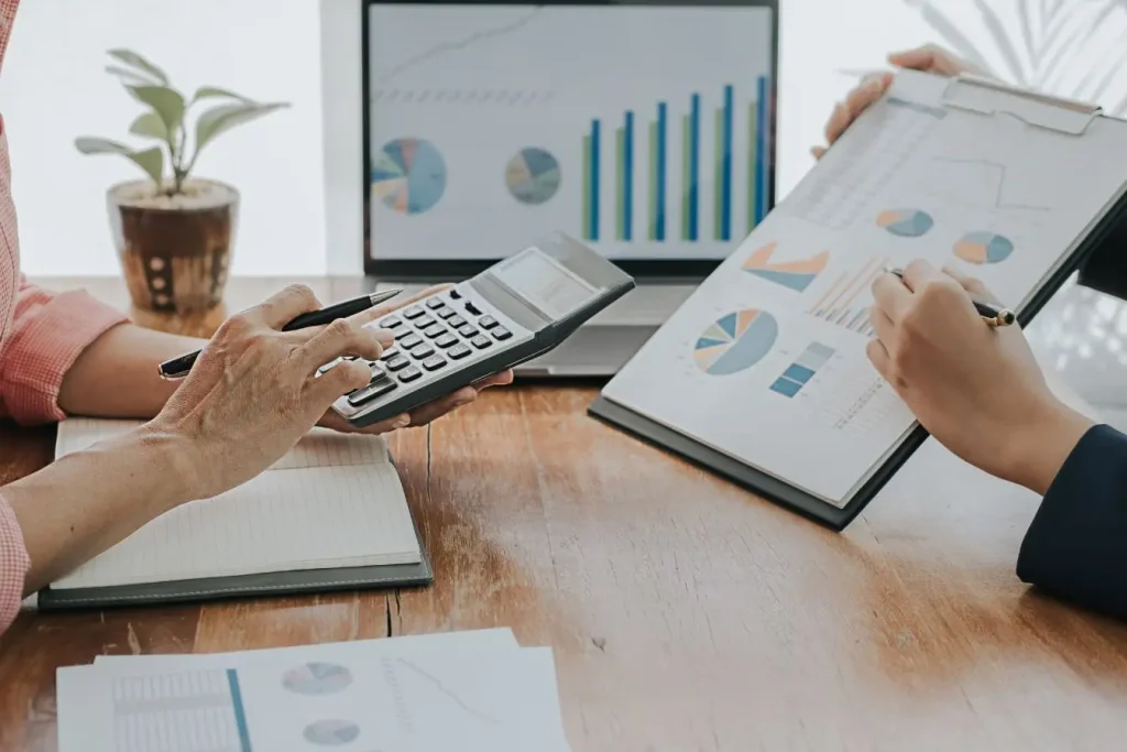 Bureau avec calculatrice et laptop, montrant la prise de risque d’une startup comparée à la prudence d’une PME dans la planification.