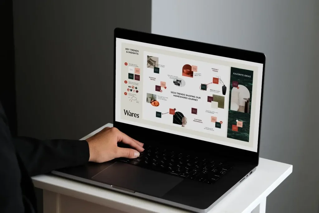 Personne utilisant un ordinateur portable affichant une présentation sur tendances et préférences, illustrant un travail pour mesurer la notoriété d’une marque.