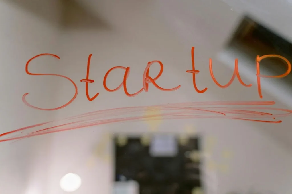 Mot Startup écrit en rouge sur surface transparente, image illustrant le lever de fonds pour une startup et la vision entrepreneuriale.