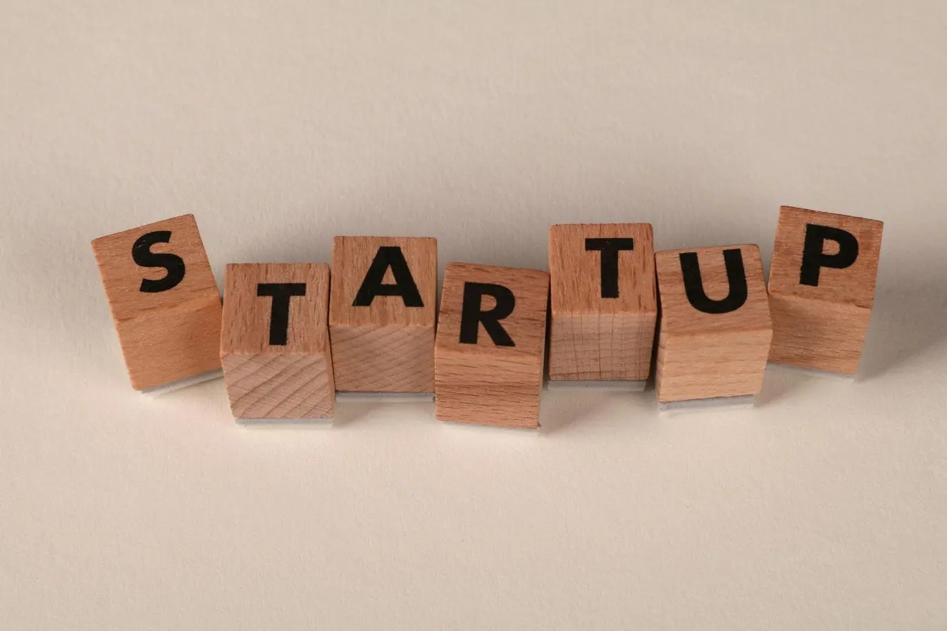 Blocs en bois formant startup, image illustrant les différences clés entre incubateur et accélérateur dans le parcours entrepreneurial.