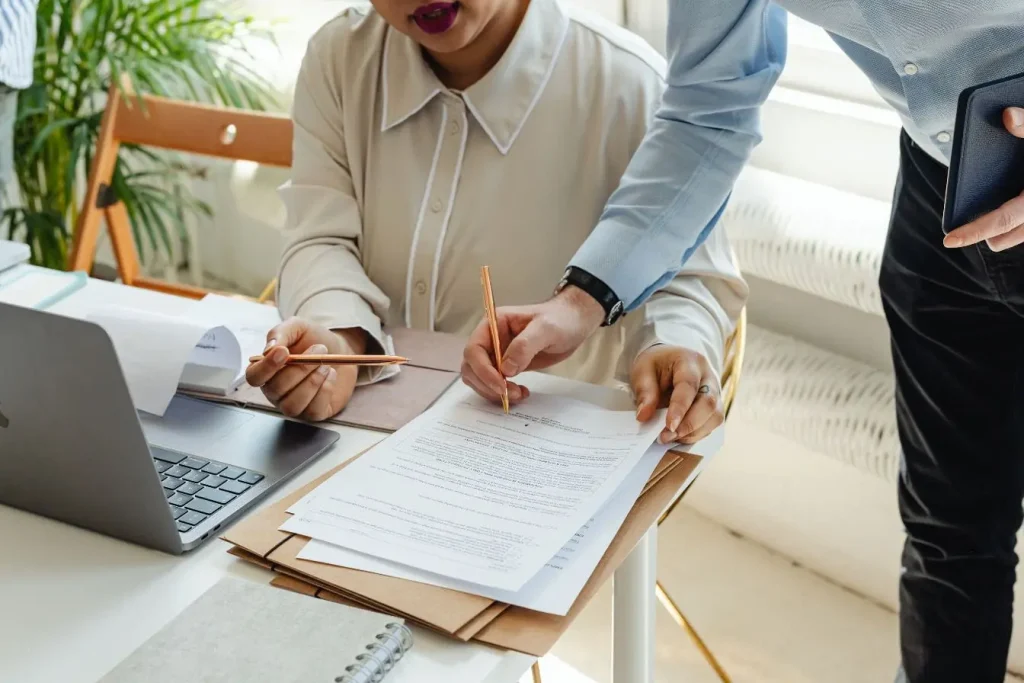 Deux personnes travaillent ensemble sur documents financiers, image illustrant valoriser une startup par collaboration et stratégie partagée.