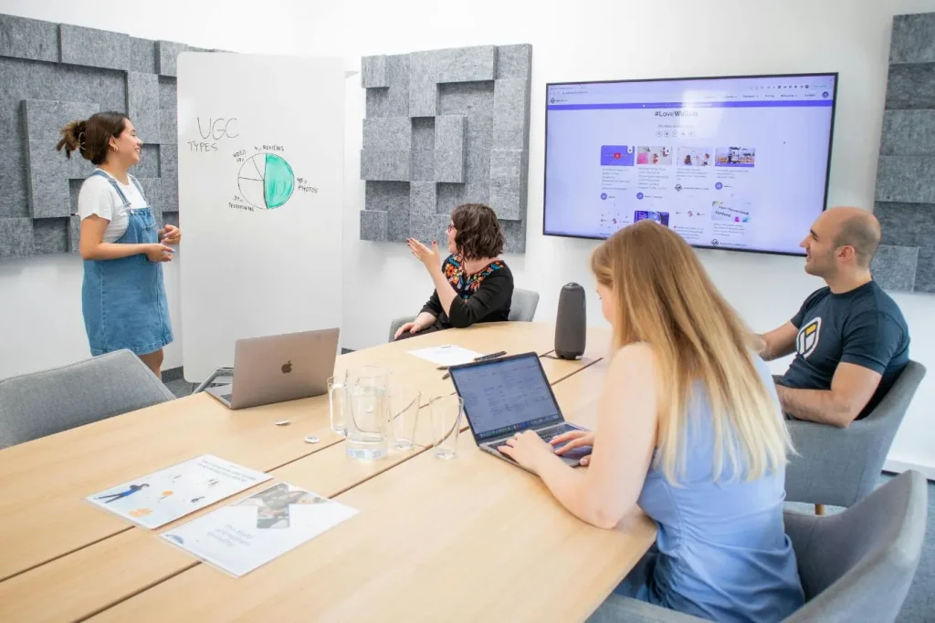 Réunion d’équipe autour d’un tableau reflétant la distinction entre marketing centré sur la vente et communication centrée sur le message.