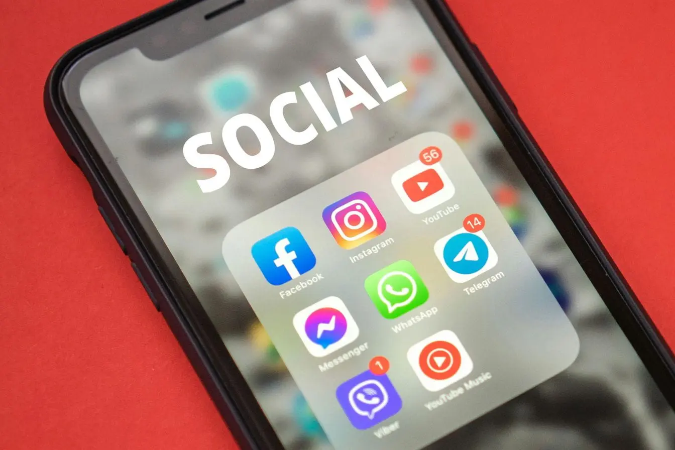 Applications regroupées dans un dossier social sur téléphone, représentant la visibilité réduite liée au shadow ban sur les réseaux sociaux.