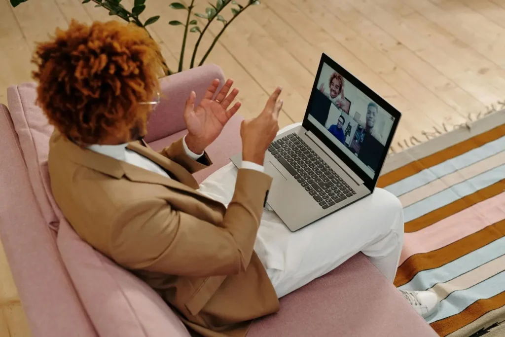Écran d’ordinateur portable affichant quatre participants en appel vidéo, représentant la création d’une communauté en ligne et la collaboration numérique.