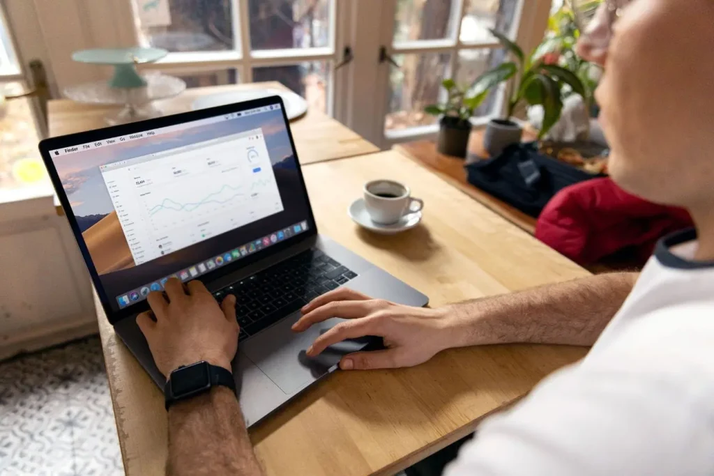 Personne assise devant un laptop affichant des graphiques colorés, image qui illustre l’utilisation de Google Analytics 4 pour analyser les données web.