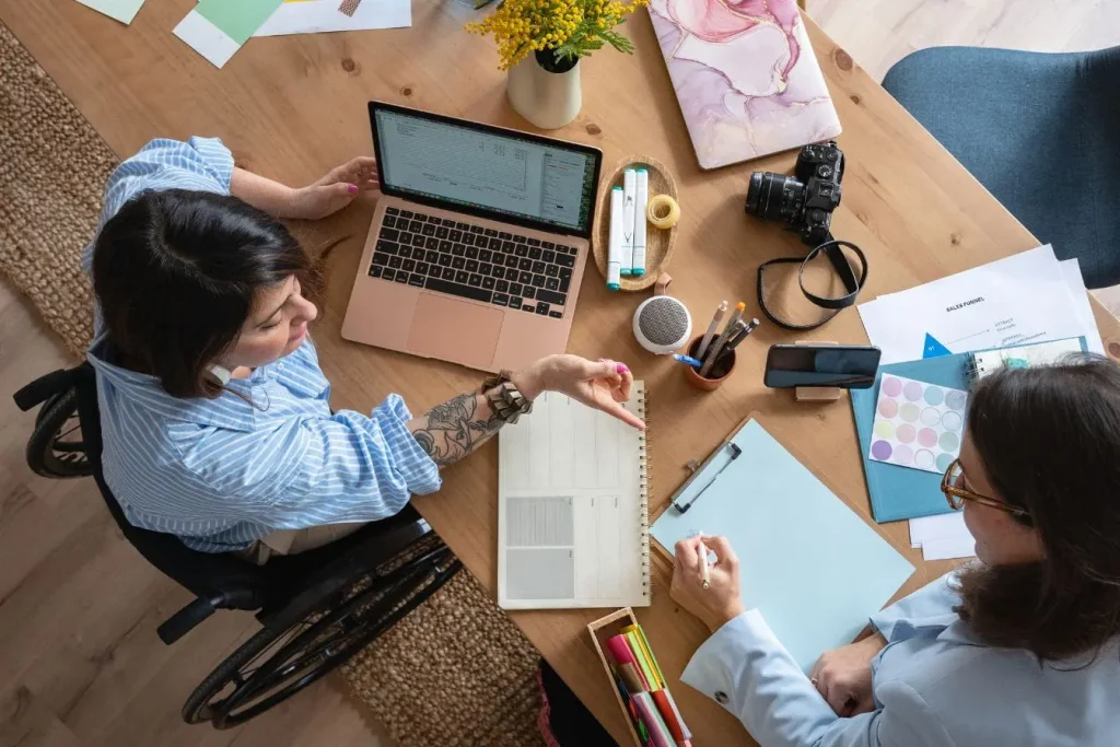 Deux personnes collaborant autour d’un bureau inclusif, image qui illustre la force de l’employer branding dans un environnement créatif et ouvert.
