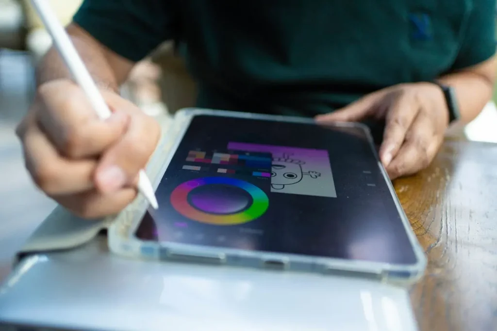 Personne utilisant un stylet sur tablette pour colorer un dessin numérique, image qui illustre la créativité du motion design.