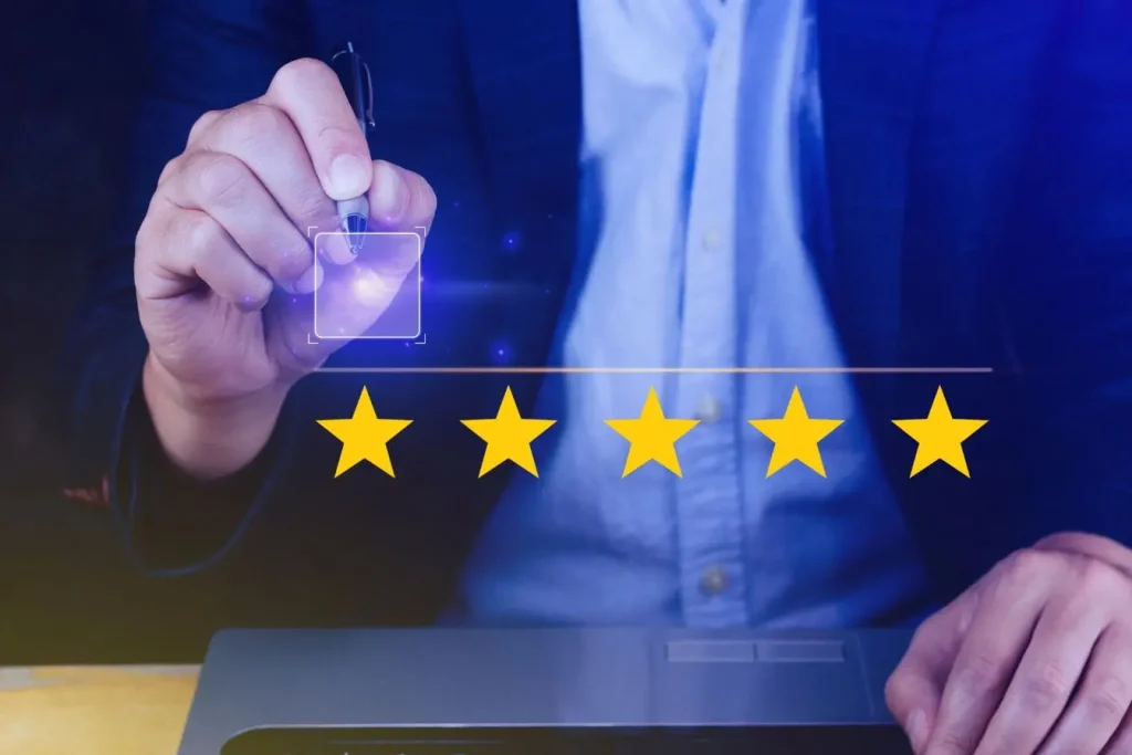 Personne en costume devant laptop sélectionnant des étoiles jaunes, image qui illustre une étape clé du customer journey lié à la satisfaction