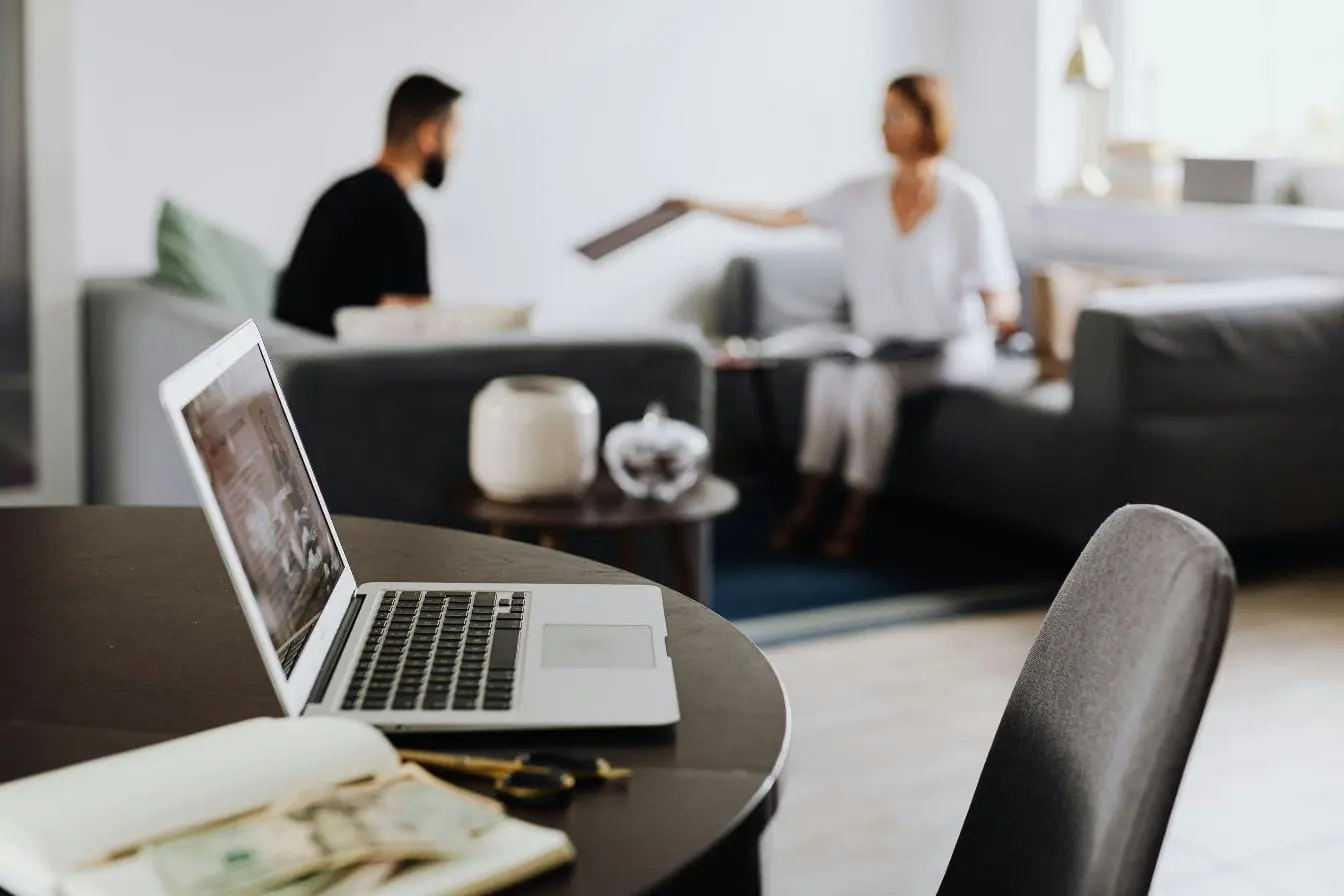 onboarding client Table avec ordinateur portable ouvert, carnet et lunettes, image qui illustre un moment d’onboarding client dans un cadre convivial.
