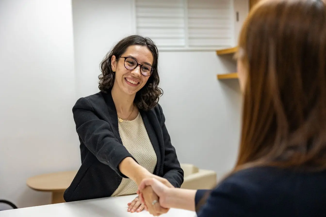 Deux personnes en costume échangent une poignée de main lors d’un entretien, image qui illustre le recrutement professionnel facilité par LinkedIn.