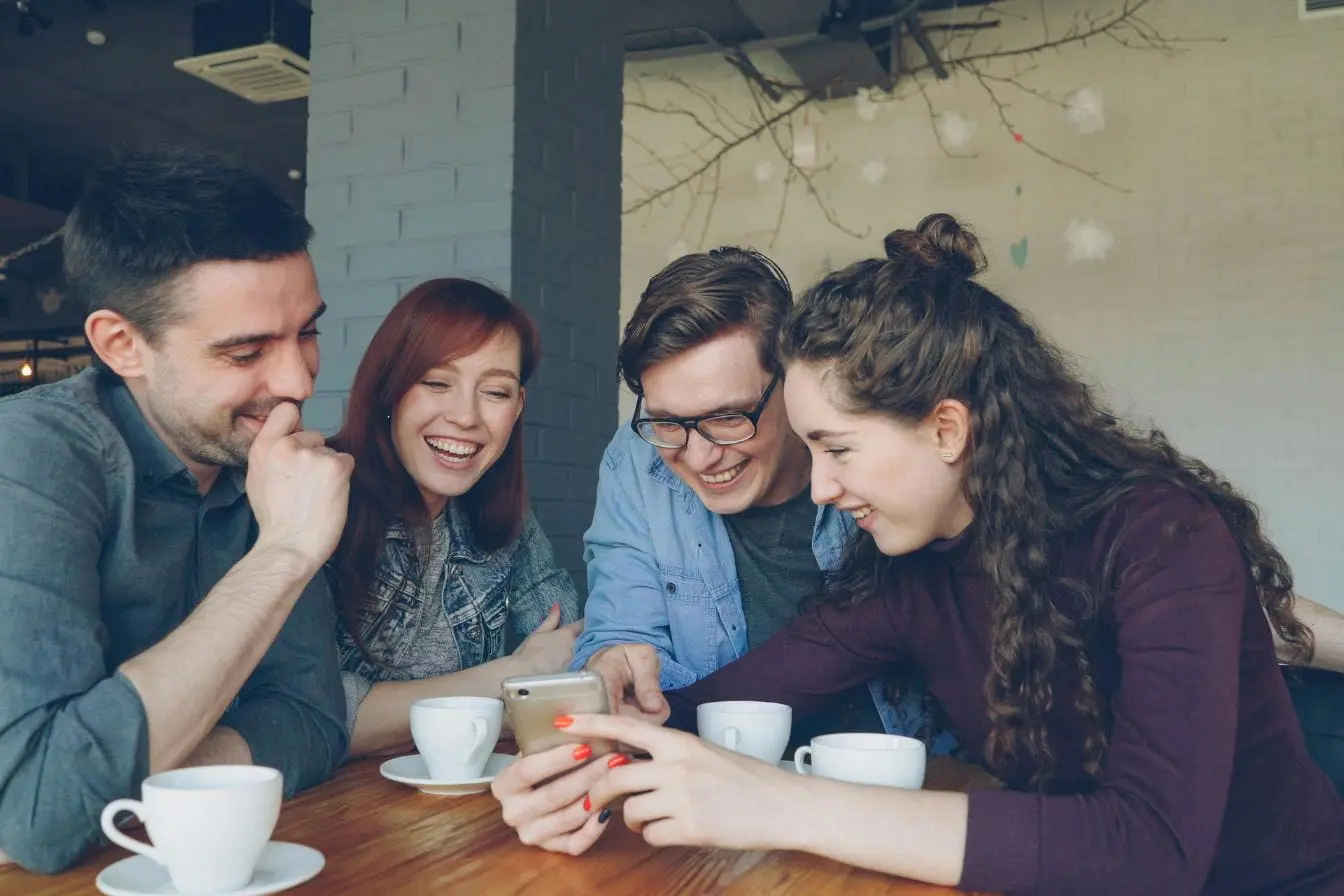 social proof Quatre personnes attentives au même écran, illustration du pouvoir du social proof.