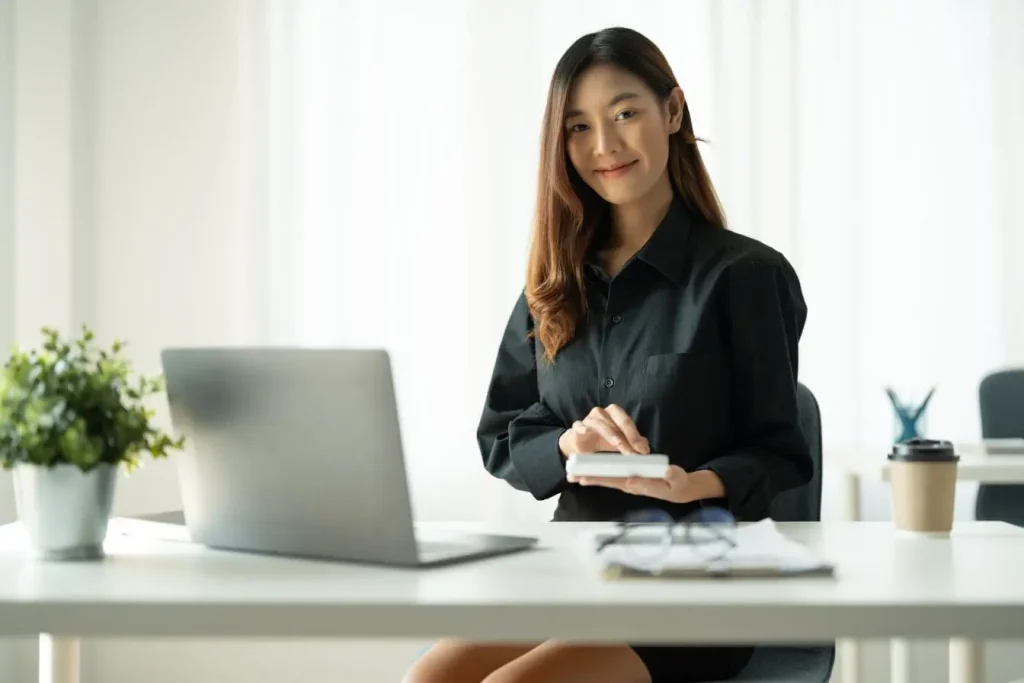 Personne assise à un bureau moderne avec laptop et smartphone, image qui illustre la stratégie Account Based Marketing centrée sur les comptes clés.