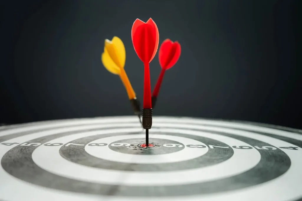 Cible de fléchettes avec trois tirs proches du centre, image qui illustre la précision et l’efficacité recherchées dans un funnel marketing.