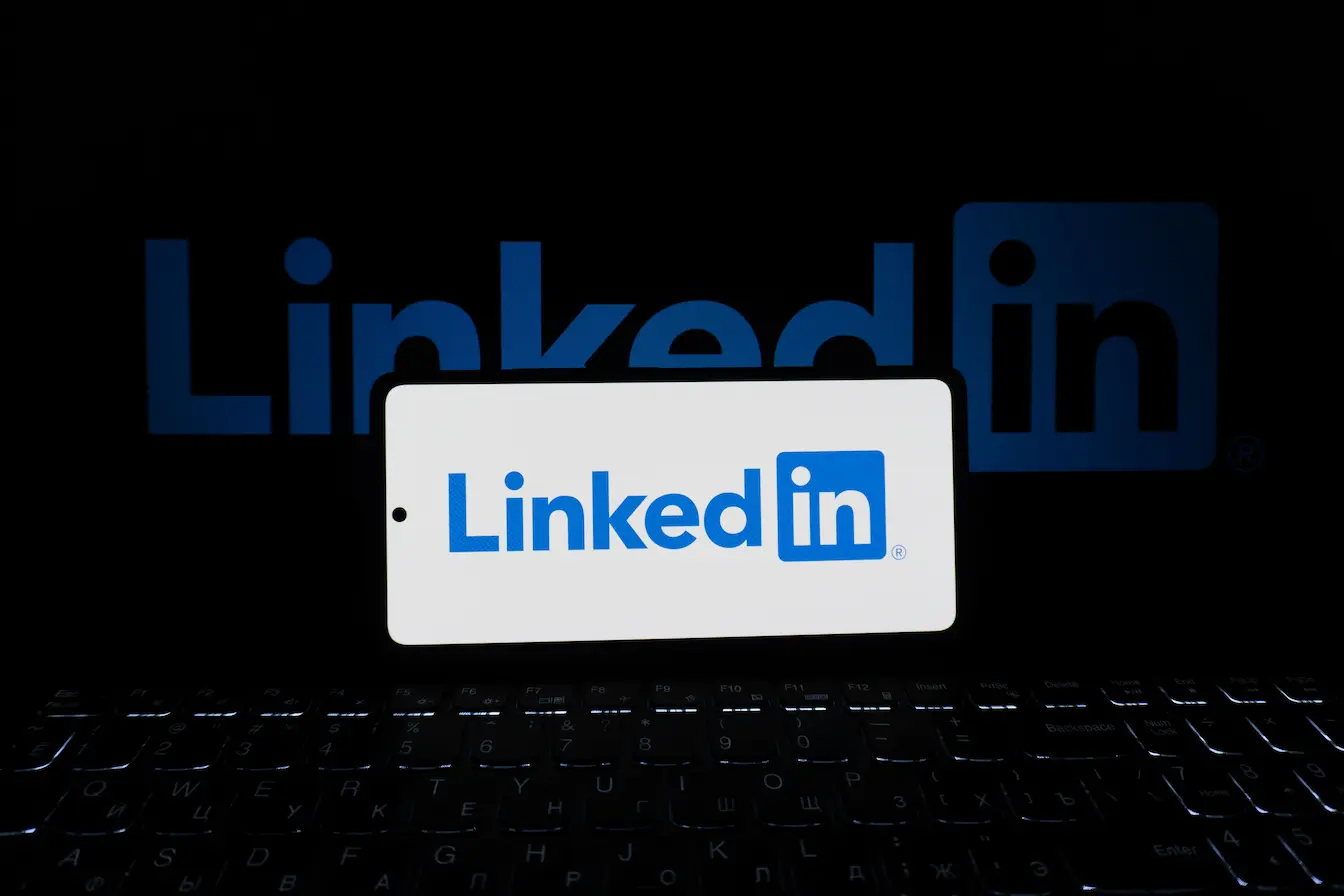 LinkedIn Écran de smartphone affichant logo LinkedIn posé sur clavier, reflet des pratiques de personal branding sur LinkedIn.