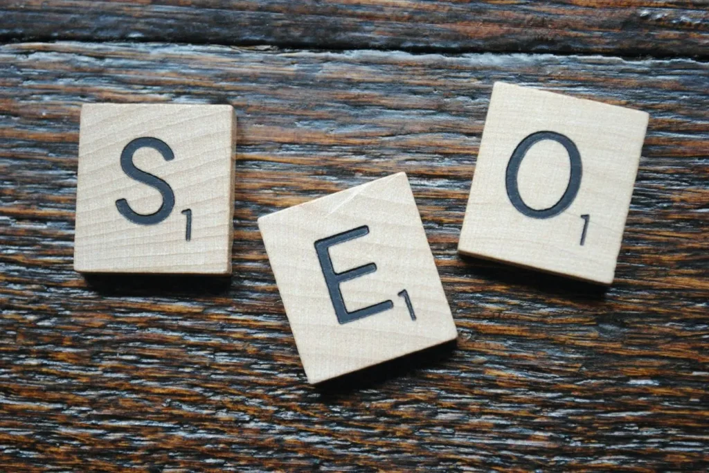 Trois tuiles de Scrabble formant mot SEO, reflet d’une cannibalisation SEO où plusieurs pages ciblent mêmes mots‑clés.