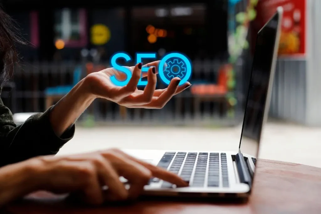 Écran d’ordinateur portable avec main affichant texte SEO lumineux, image claire illustrant les conséquences du zéro clic pour le SEO.