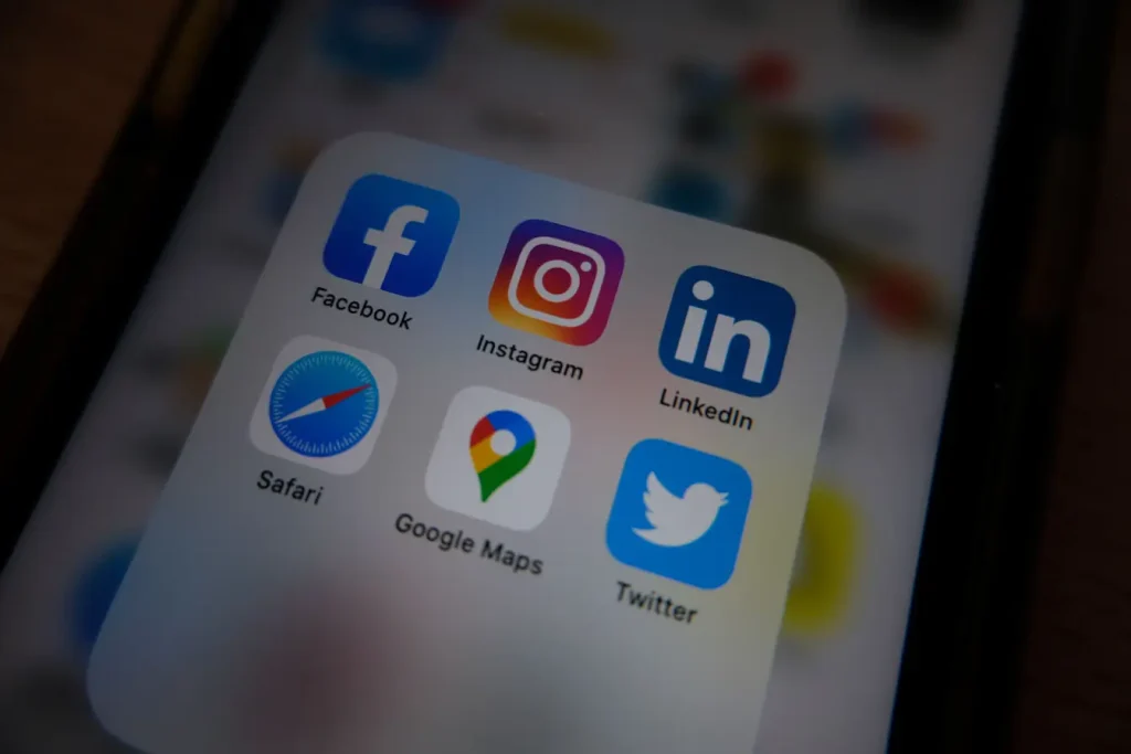 Écran de smartphone affichant dossier d’applications avec logo LinkedIn visible, reflet des pratiques de personal branding sur LinkedIn.