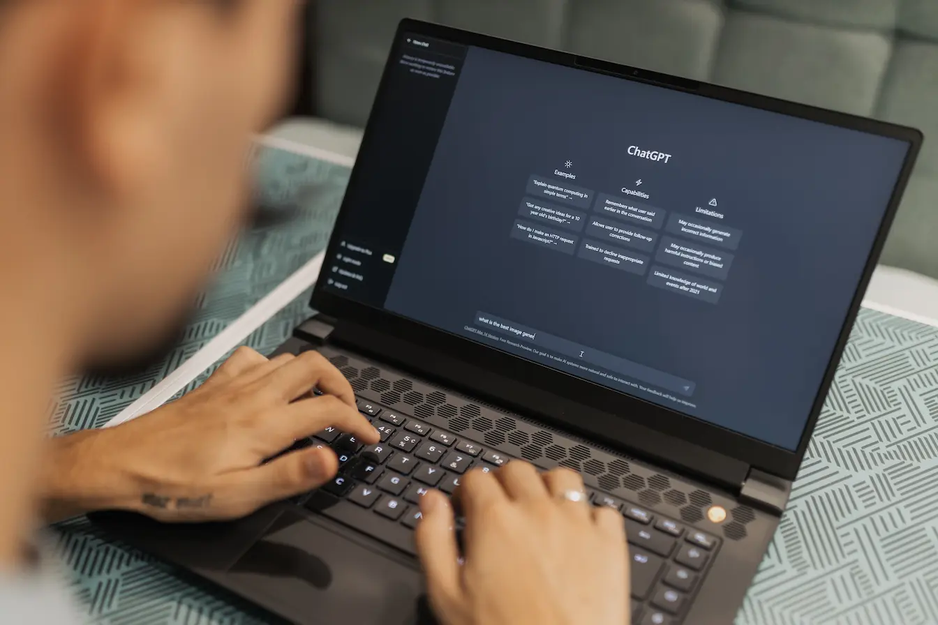 interface ChatGPT Personne tapant sur ordinateur avec interface ChatGPT ouverte, image qui illustre la recherche du prompt parfait pour ChatGPT.