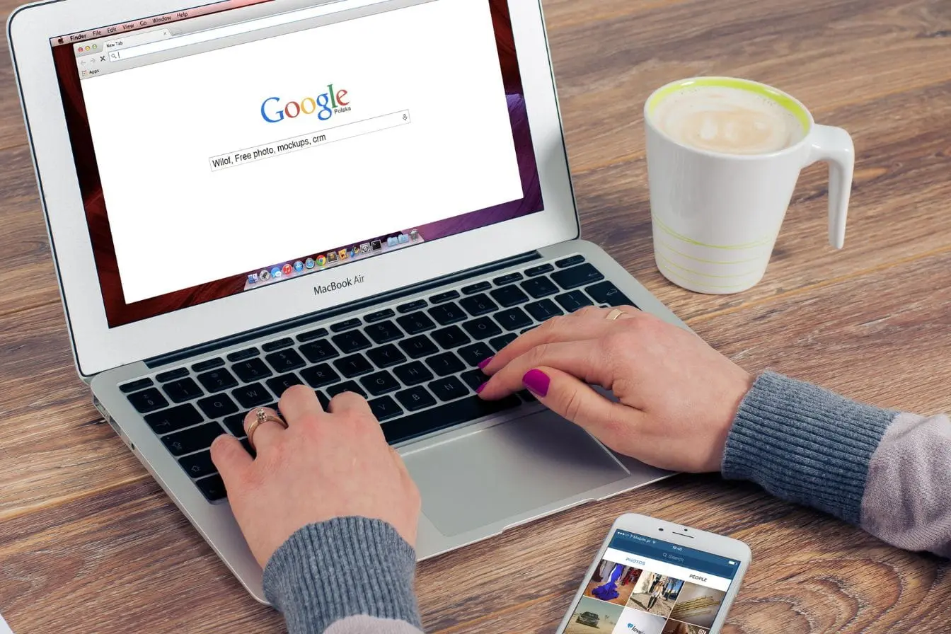Utilisateur tapant requête sur MacBook Air affichant Google, reflet des enjeux du zéro clic et ses conséquences sur le SEO.
