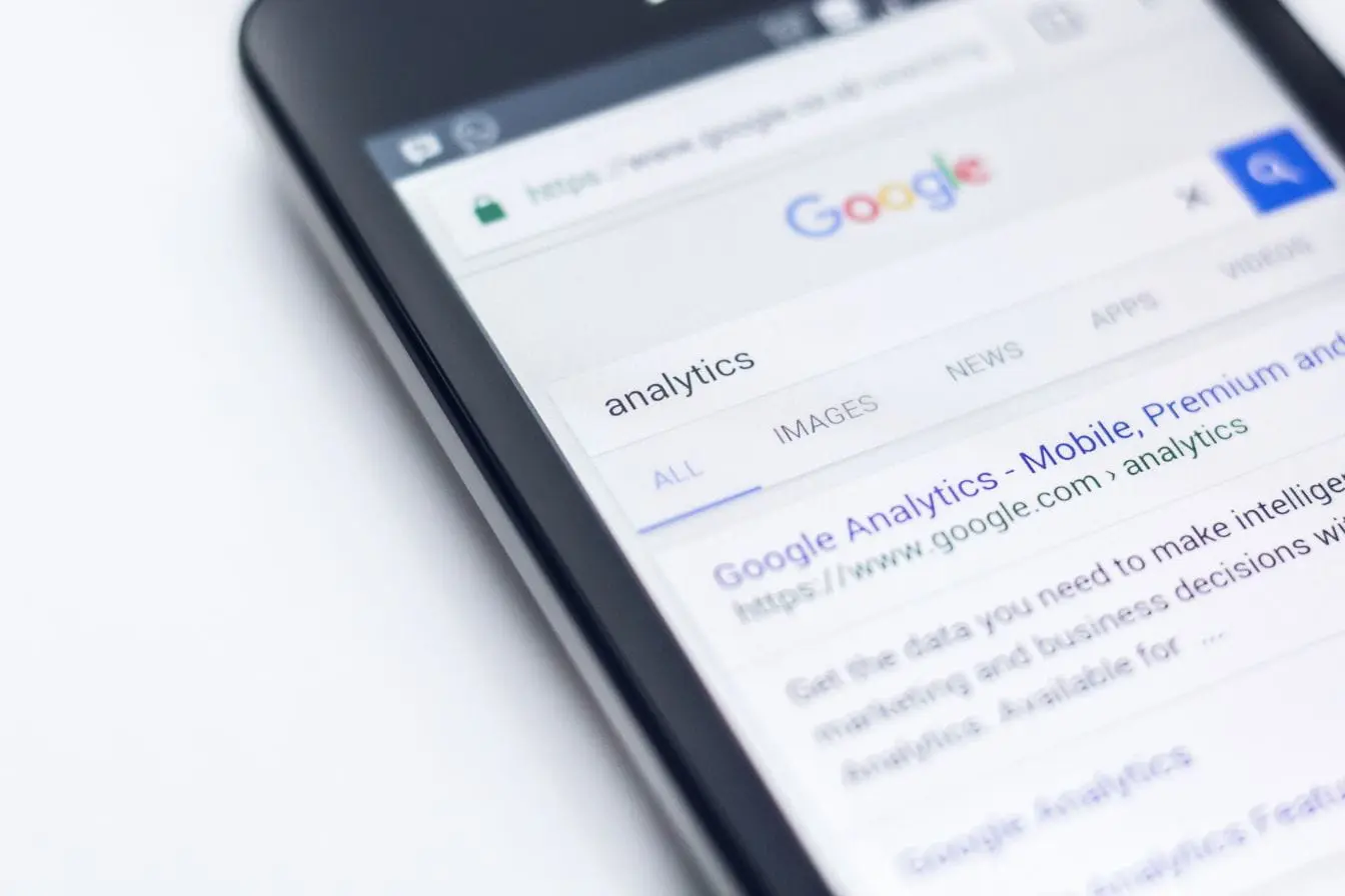 recherche Google Écran de smartphone affichant recherche Google sur analytics, reflet des critères EAT de Google pour expertise et fiabilité du contenu.