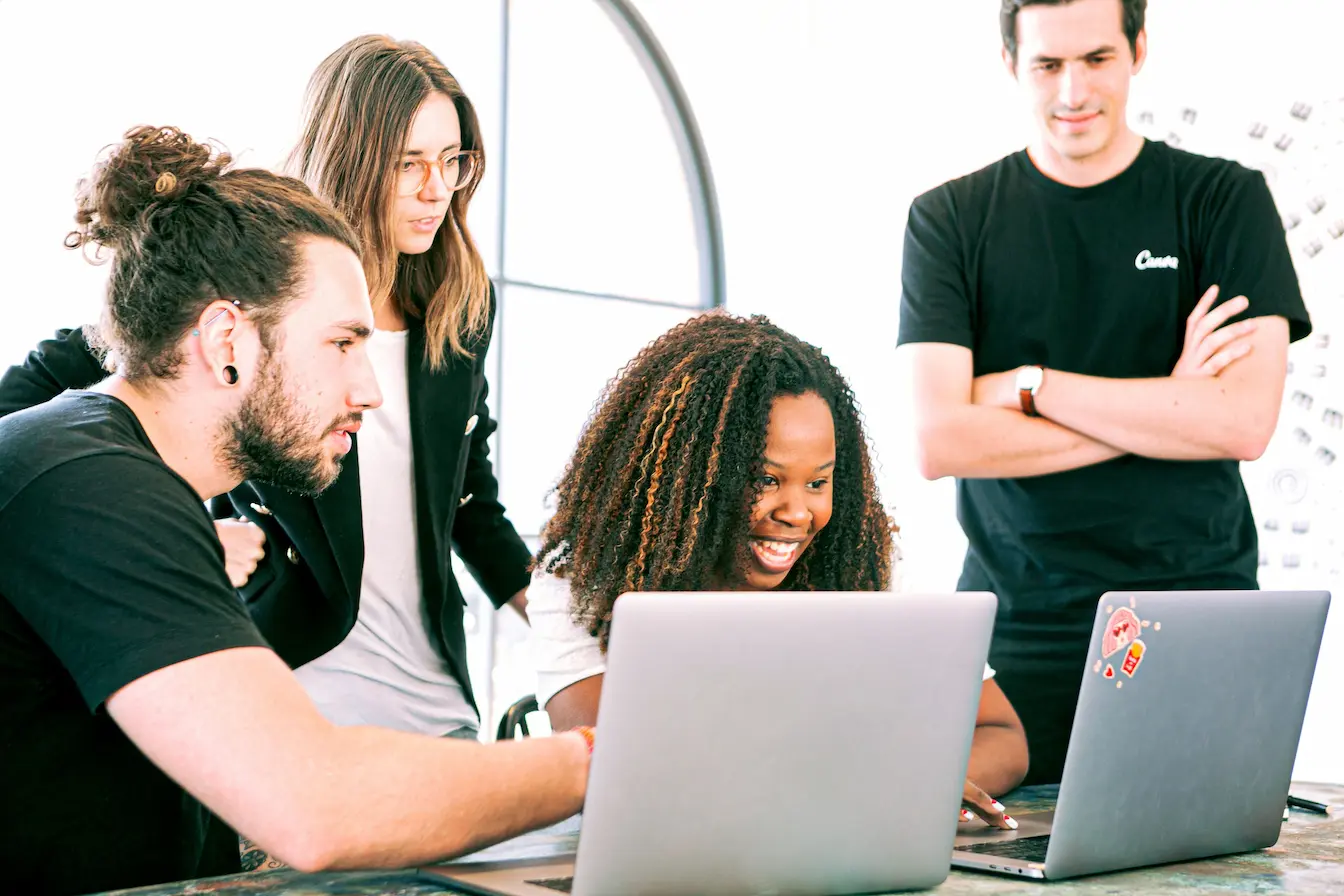 Groupe de jeunes professionnels Groupe de jeunes professionnels réunis autour d’ordinateurs portables, symbole du travail collaboratif lié à la valorisation d’une startup.