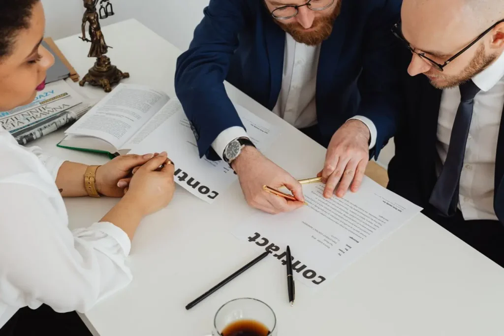 Personnes en réunion examinant contrats et graphiques, illustration typique des choix de modèle économique.