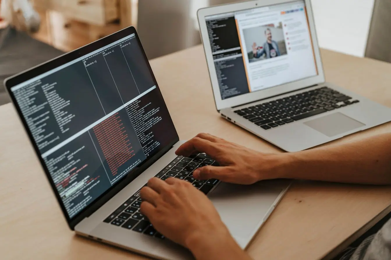Personne tapant sur clavier devant écran affichant code, symbole des pratiques liées à l’accessibilité web et aux normes RGAA.
