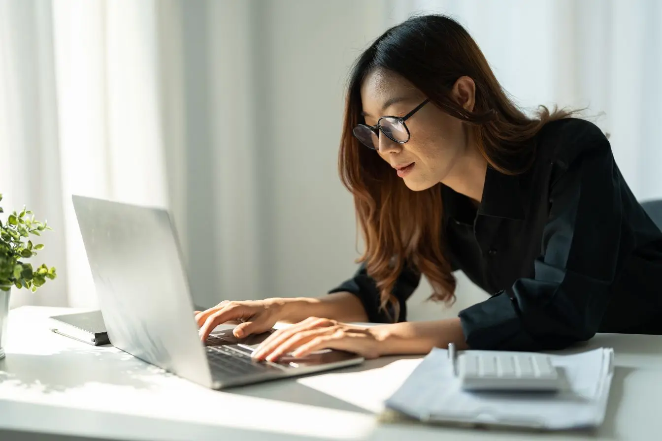 cybersécurité pour les TPE Personne travaillant sur un ordinateur portable dans un bureau lumineux, illustrant les bonnes pratiques de cybersécurité pour protéger une TPE contre les menaces numériques