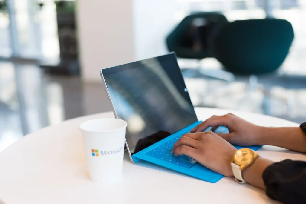 Personne travaillant sur une tablette équipée d’un clavier dans un espace moderne, illustrant les pratiques DevOps favorisant collaboration et automatisation